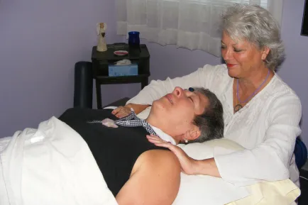 Woman giving another woman a relaxing shoulder massage.